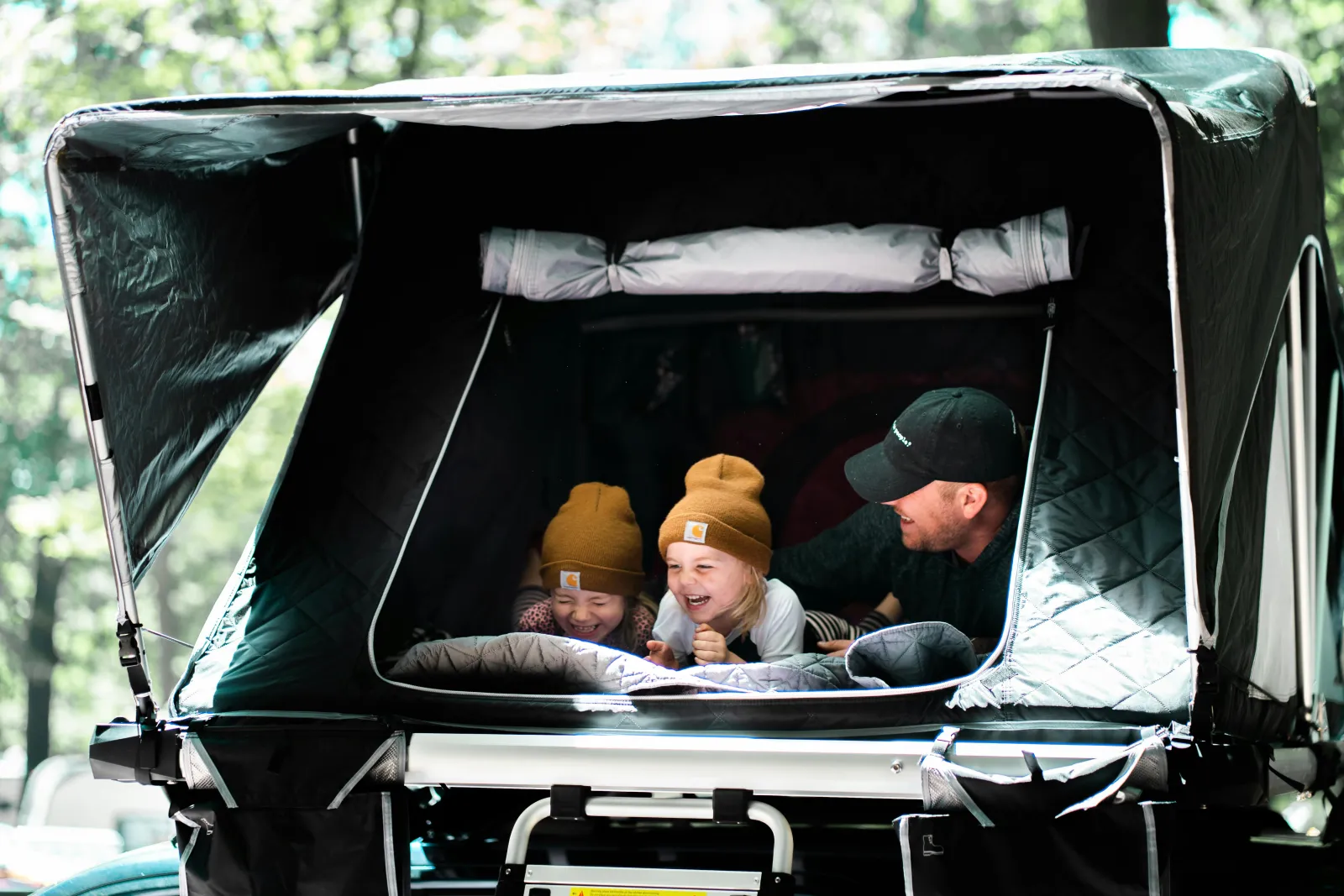 Familie samlet i et oppslått taktelt på bilen, godt forberedt og trygt installert på tur
